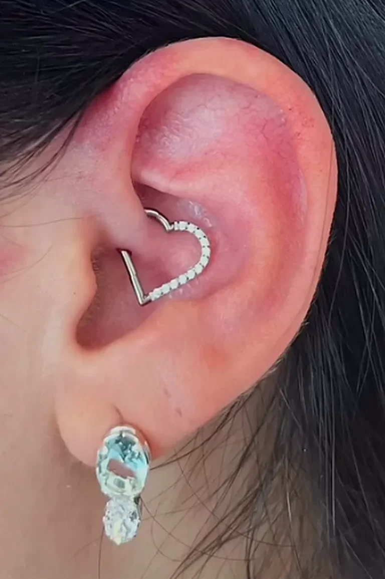 Piercing daith com argola em formato de coração cravejada de zircônias, feito na Visão Tattoo em Curitiba