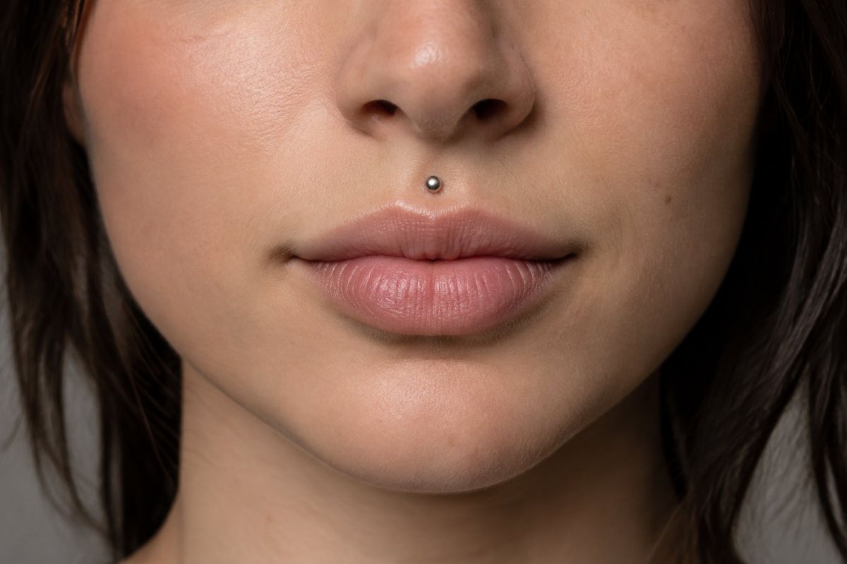 Piercing medusa: pessoa com um piercing no centro do lábio superior.
